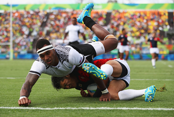 RIO DE JANEIRO, BRAZIL - AUGUST 11:  Kazushi Hano of Japan scores a try under pressure from Semi Kunatani of Fiji score a try during the Men's Rugby Sevens semi final match between Fiji and Japan on Day 6 of the Rio 2016 Olympics at Deodoro Stadium on August 11, 2016 in Rio de Janeiro, Brazil.  (Photo by Mark Kolbe/Getty Images)