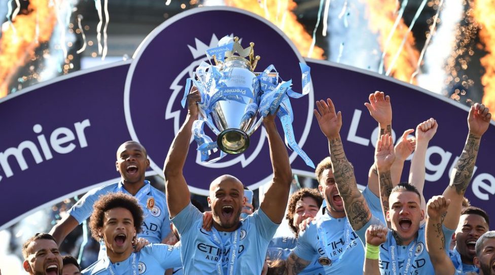 Manchester City's Belgian defender Vincent Kompany (C) holds up the Premier League trophy after their 4-1 victory in the English Premier League football match between Brighton and Hove Albion and Manchester City at the American Express Community Stadium in Brighton, southern England on May 12, 2019. - Manchester City held off a titanic challenge from Liverpool to become the first side in a decade to retain the Premier League on Sunday by coming from behind to beat Brighton 4-1 on Sunday. (Photo by Glyn KIRK / AFP) / RESTRICTED TO EDITORIAL USE. No use with unauthorized audio, video, data, fixture lists, club/league logos or 'live' services. Online in-match use limited to 120 images. An additional 40 images may be used in extra time. No video emulation. Social media in-match use limited to 120 images. An additional 40 images may be used in extra time. No use in betting publications, games or single club/league/player publications. /         (Photo credit should read GLYN KIRK/AFP/Getty Images)