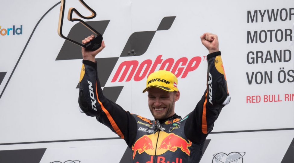 SPIELBERG, AUSTRIA - AUGUST 11:  Brad Binder of South Africa and Red Bull KTM  Ajo celebrates the victory at the end of the Moto2 race on the podium during the MotoGp of Austria - Race at Red Bull Ring on August 11, 2019 in Spielberg, Austria. (Photo by Mirco Lazzari gp/Getty Images)