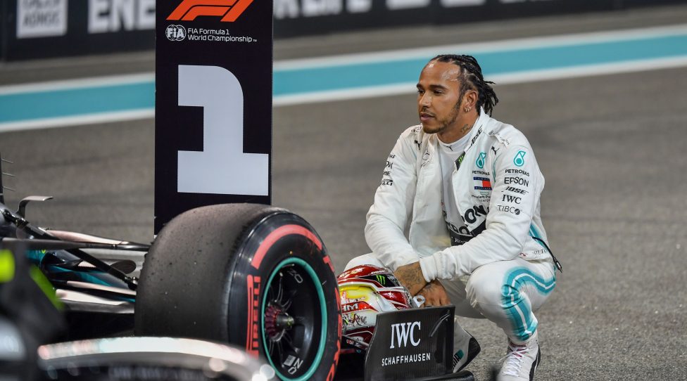 Mercedes' British driver Lewis Hamilton sits next to his car as he celebrates winning the pole position after the qualifying session at the Yas Marina Circuit in Abu Dhabi, a day ahead of the final race of the season, on November 30, 2019. (Photo by ANDREJ ISAKOVIC / AFP) (Photo by ANDREJ ISAKOVIC/AFP via Getty Images)
