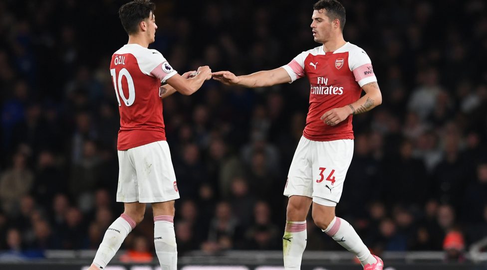 LONDON, ENGLAND - OCTOBER 22:  Mesut Ozil of Arsenal passes the captaisn armband to Granit Xhaka during the Premier League match between Arsenal FC and Leicester City at Emirates Stadium on October 22, 2018 in London, United Kingdom.  (Photo by David Price/Arsenal FC via Getty Images)