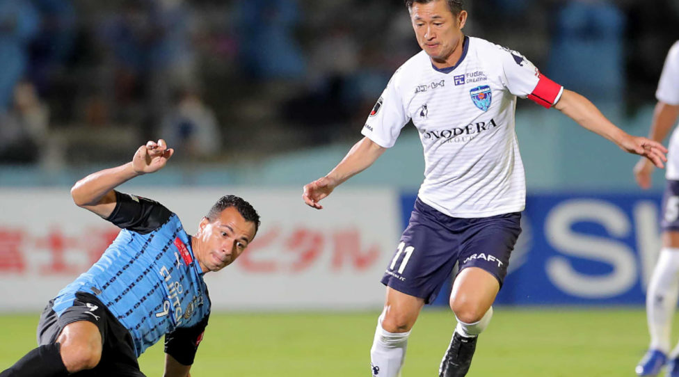 Yokohama FC forward Kazuyoshi Miura (R) is tackled by Kawasaki Frontale forward Leandro Damiao during the J-League football match between Kawasaki Frontale and Yokohama FC at Todoroki Athletics stadium in Kawasaki on September 23, 2020. - Miura was in the starting line-up for Yokohama FC's clash against Kawasaki Frontale, and at 53 years, six months and 28 days old easily smashed the record for oldest-ever J-League first division starter set by Masashi Nakayama in 2012. (Photo by STR / JIJI PRESS / AFP) / Japan OUT (Photo by STR/JIJI PRESS/AFP via Getty Images)