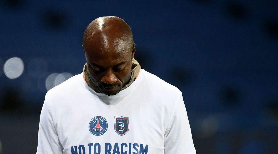 Istanbul Basaksehir's Cameroonian assistant coach Pierre Webo, wearing a tshirt reading "No to racism", looks on during warm-up before the UEFA Champions League group H football match between Paris Saint-Germain (PSG) and Istanbul Basaksehir FK at the Parc des Princes stadium in Paris, on December 9, 2020. - The group game in Paris, which was goalless at the time, was suspended when both teams left the pitch on December 8, 2020 after a touchline argument erupted when the Romanian fourth official, Sebastian Coltescu, appeared to describe Basaksehir assistant coach Pierre Webo, a former Cameroon international player, as "black", or "negru" in Romanian and will resume on December 9 where it left off, in the 14th minute, with a different set of officials. (Photo by FRANCK FIFE / AFP) (Photo by FRANCK FIFE/AFP via Getty Images)