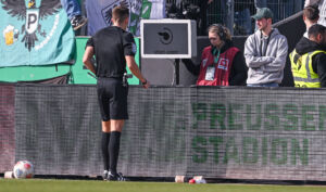 Beim Zweitliga-Spiel zwischen Münster und Hertha BSC will der Schiedsrichter ein Foul überprüfen. Doch der Bildschirm bl